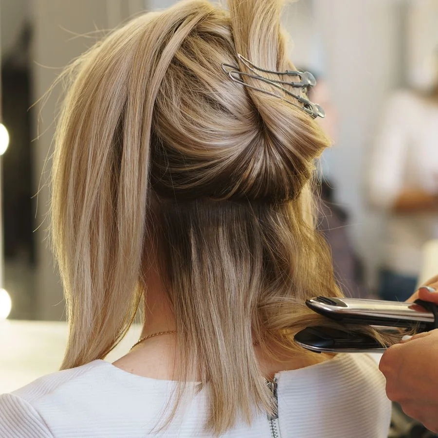 Alisado con plancha sobre cabello con mechas en el área de estilismo de Authentic Studio C&G